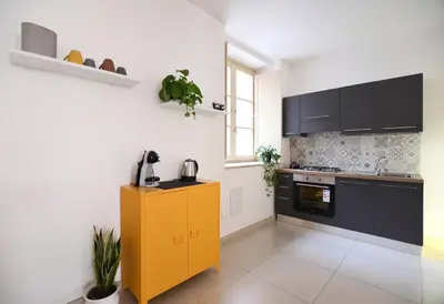 a kitchen with black cabinets and a yellow cabinet at iFlat Le stanze del Principe in Palermo