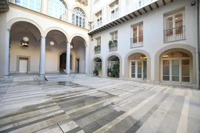 an empty courtyard of a building with columns at iFlat Le stanze del Principe in Palermo