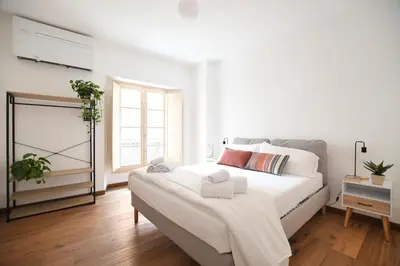 a white bedroom with a large bed and a window at iFlat Le stanze del Principe in Palermo