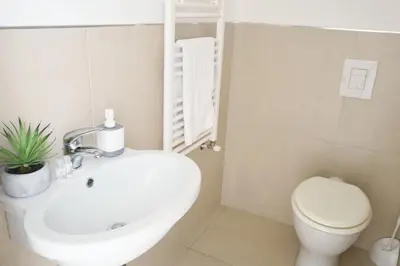 a bathroom with a white sink and a toilet at iFlat Le stanze del Principe in Palermo