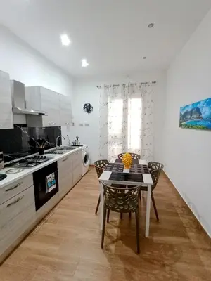 a kitchen with a table and chairs in a room at Yris House in Palermo