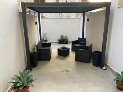 an empty room with chairs and plants in a building at Yris House in Palermo