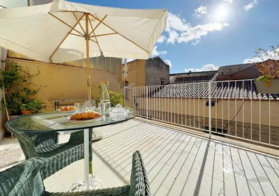 a patio table with an umbrella on a balcony at Solemar Sicilia - Terrazza del Merlo in Palermo