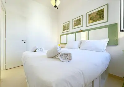 a white bedroom with two beds with towels on them at Solemar Sicilia - Terrazza del Merlo in Palermo