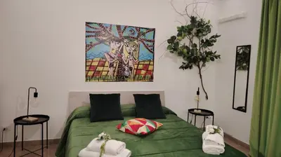 a bedroom with a green bed with towels on it at Nanà Apartment in Palermo