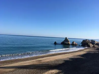 a beach with some rocks in the water at Noravilla con piscina fra mare e montagne in Mandra Capreria