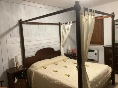 a bedroom with a bed with a canopy at Noravilla con piscina fra mare e montagne in Mandra Capreria