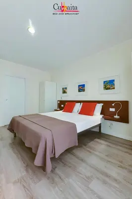 a bedroom with a large bed with red pillows at B&B Cubbaita in Palermo