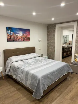 a bedroom with a large bed with a painting on the wall at Lolli House in Palermo