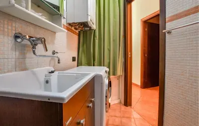 a bathroom with a sink and a green shower curtain at Gorgeous Apartment In Palermo With Wifi in Palermo