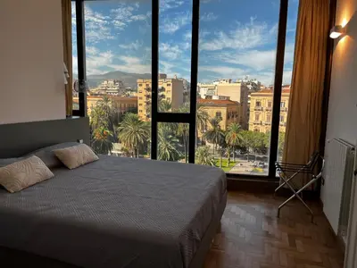 a bedroom with a bed with a view of a city at politeama view apartment in Palermo