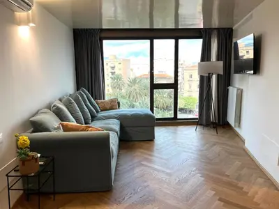 a living room with a couch and a large window at politeama view apartment in Palermo