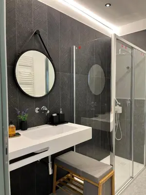 a bathroom with a sink and a mirror and a shower at politeama view apartment in Palermo