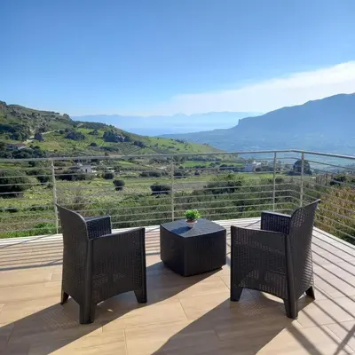 two chairs and a table on a deck with a view at Villa Saint George in Scopello