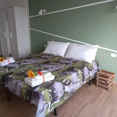 a bedroom with a bed with a colorful comforter at Villa Saint George in Scopello