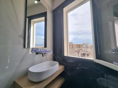 a bathroom with a white sink and two windows at MaXelA Penthouse by Holiday World in Palermo
