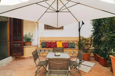 a table and chairs under an umbrella on a patio at Giardino del Foro in Palermo