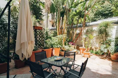 a patio with a table and chairs and plants at Giardino del Foro in Palermo