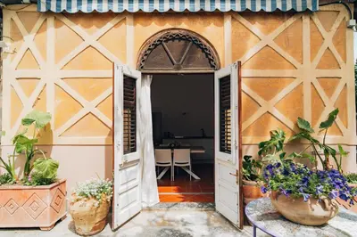 an open door to a building with plants in the doorway at Giardino della Kalsa in Palermo