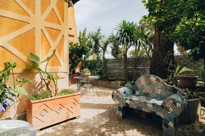 a patio with a couch and a table and some plants at Giardino della Kalsa in Palermo