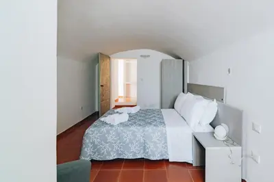 a bedroom with a large bed and a chair at Giardino della Kalsa in Palermo