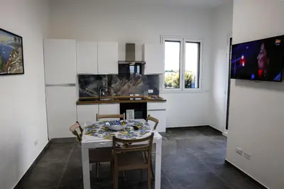 a kitchen with a table and chairs in a room at Trabia Casa Bianca A in Mandra Capreria