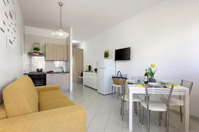 a living room and kitchen with a table and a couch at Casa Vacanze Margherita in San Vito lo Capo