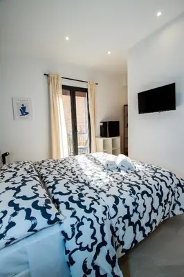 a bedroom with a bed with a blue and white comforter at Porta Nuova Suite & Rooms city center in Palermo