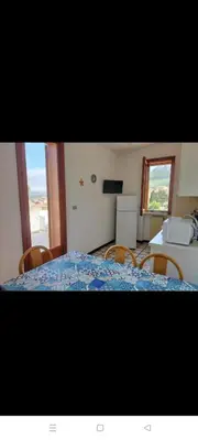 a bedroom with a bed with chairs and a window at Villa Rizzo in Castellammare del Golfo