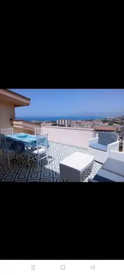 a patio with chairs and tables and a view of the ocean at Villa Rizzo in Castellammare del Golfo