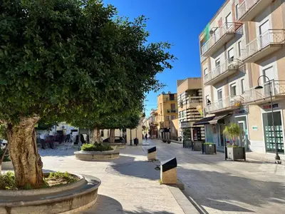 a street in a city with a tree and buildings at Apartment Pirandello by Interhome in Balestrate