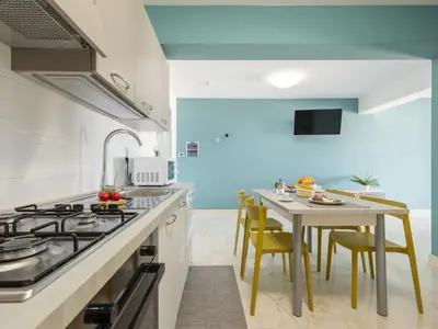 a kitchen with a stove and a table with chairs at Apartment Pirandello by Interhome in Balestrate