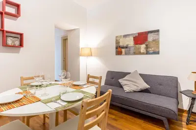 a living room with a table and a couch at Piazza Marina Holiday House by DomuSicily in Palermo
