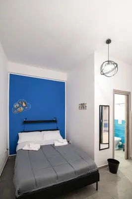 a bed with a blue headboard in a room at Splendori Rooms in Palermo