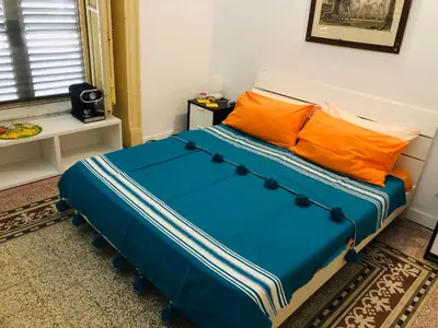 a blue bed with orange pillows in a room at B&B Giulio Cesare 24 in Palermo