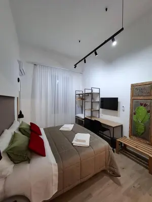 a bedroom with a large bed with a desk and a computer at Donna Rosa House in Palermo