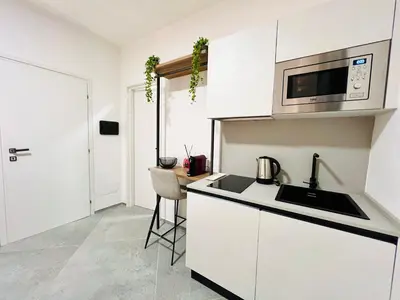 a white kitchen with a sink and a microwave at Pretoria Suites in Palermo