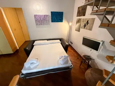 a small room with a bed and a flat screen tv at Loft in Kalsa - By Rental BeB - in Palermo