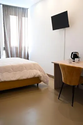 a bedroom with a bed and a desk with a television at Manno's Apartment in Palermo