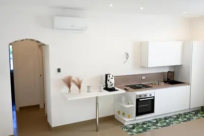 a kitchen with white cabinets and a white counter top at Manno's Apartment in Palermo