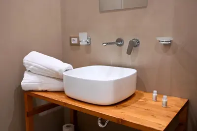 a bathroom with a white sink on a wooden table at Manno's Apartment in Palermo