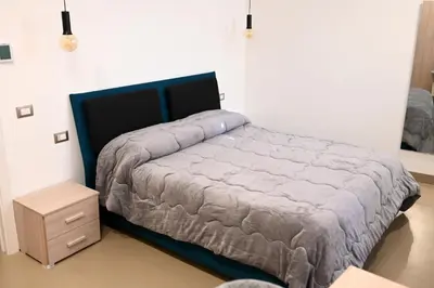 a bedroom with a bed and a night stand at Manno's Apartment in Palermo