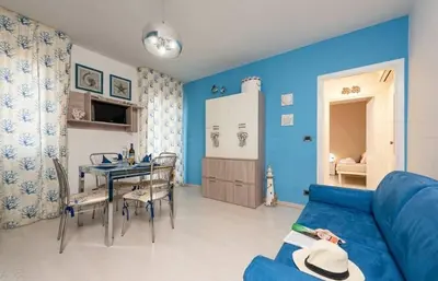a living room with blue walls and a blue couch at Residence Le Perle Beach in San Vito lo Capo