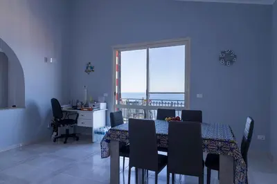 a dining room with a table and chairs and a window at Trabia Villa Bedda Mia A in Trabia
