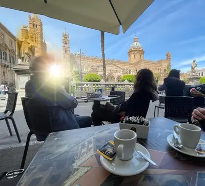 a group of people sitting at a table in front of a building at #Secretplace in Palermo