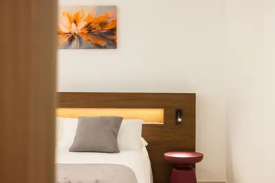 a bedroom with a bed and a painting on the wall at Nora's Suites in Palermo