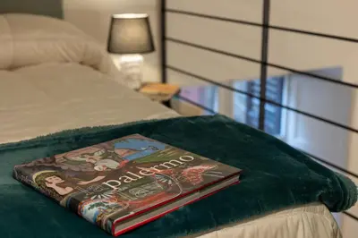 a book sitting on top of a bed at Maison Castro Casetta a Palermo in Palermo