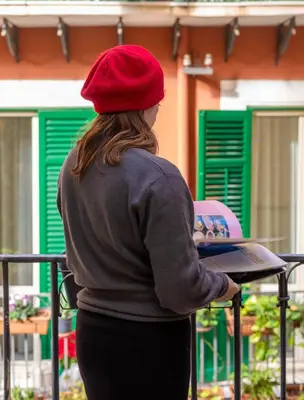 a woman in a red hat holding a laptop at Maison Castro Casetta a Palermo in Palermo