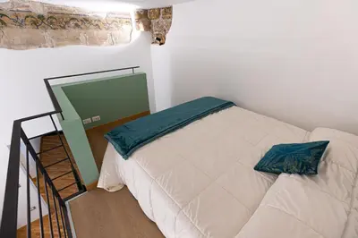 a bedroom with a bed and a ladder next to a window at Maison Castro Casetta a Palermo in Palermo