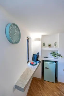 a clock on the wall of a room with a counter at Maison Castro Casetta a Palermo in Palermo